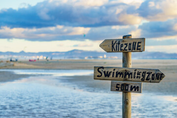 Kitezone and swimmingzone sign at beach.