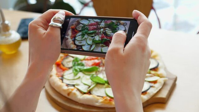 Taking pictures of pizza with a smartphone. Food blogging. Healthy delicious vegetarian pizza.
