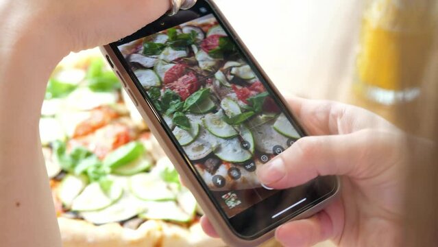 Taking pictures of pizza with a smartphone. Food blogging. Healthy delicious vegetarian pizza.