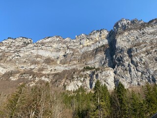Steep stone cliffs of the alpine peak Chüehoren over the river Löntsch and over the canyon Löntschtobel at foot of the alpine reservoir Klöntalersee (or Kloentalersee) - Canton of Glarus, Switzerland