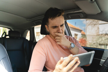A one man talking on phone and looking at navigation in a car while driving 