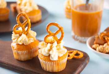 Homemade cupcakes with caramel syrup with whipped cream cheese and brezel waffles decoration