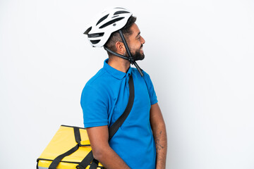 Young Brazilian man with thermal backpack isolated on white background laughing in lateral position