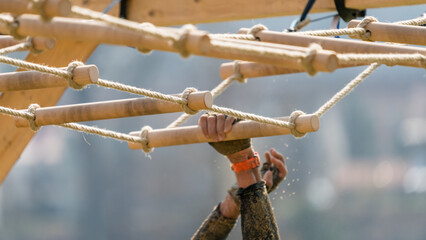 Detail of an athlete at a hanging obstacle at an obstacle course race - obrazy, fototapety, plakaty
