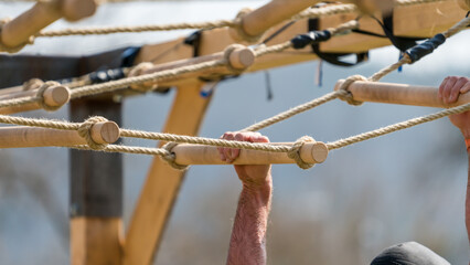 Detail of an athlete at a hanging obstacle at an obstacle course race