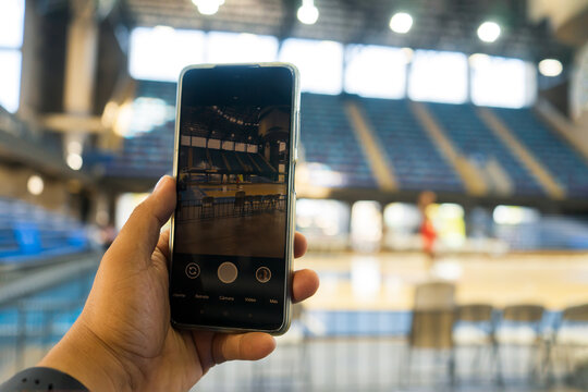 Filming with the cell phone the basketball practice of a professional team in a gym without spectators. Training, technology, communication and professionalism concept