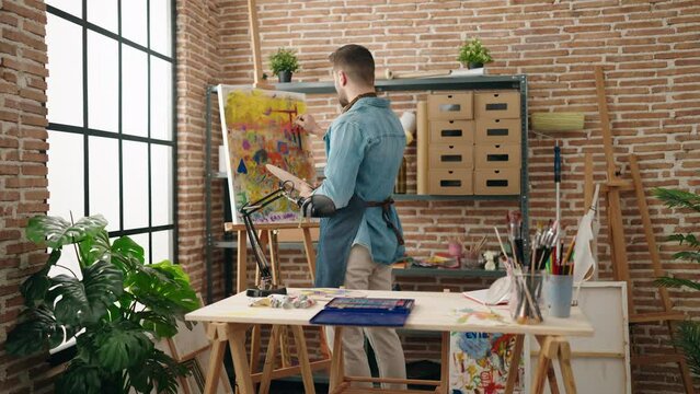 Young hispanic man concentrate finishing draw at art studio