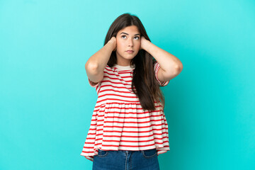 Young Brazilian woman isolated on blue background frustrated and covering ears