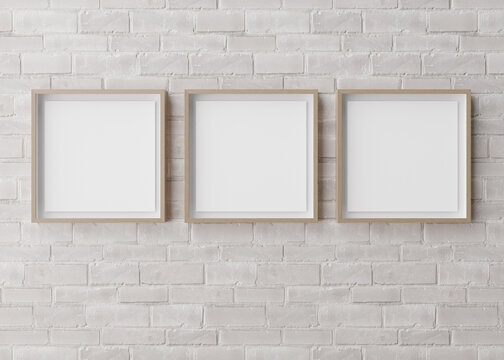 Three blank square picture frames hanging on white brick wall. Template, mock up for your picture or poster. Copy space. 3D rendering.