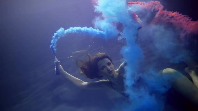 pretty mysterious woman is swimming underwater in pool and mesmerizing by look and romantic paints