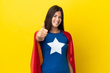Super Hero Brazilian woman isolated on yellow background with thumbs up because something good has happened