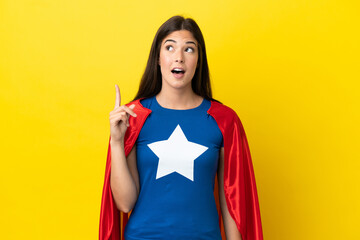 Super Hero Brazilian woman isolated on yellow background intending to realizes the solution while lifting a finger up