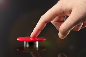 The hand presses the big red button. The concept of the threat of nuclear war. A threat to the world with a nuclear suitcase and a bomb. The hand presses the rocket launch button. - obrazy, fototapety, plakaty