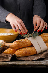 Fragrant fresh baguette with woman hands great background.