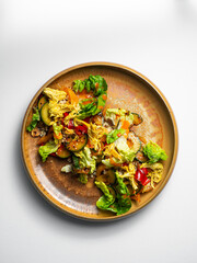 Cesar Salad with quinoa , chicken, cucumbers, pepper, sesam, kimchi.  On a ceramic plate, with a white  background