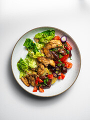 Grilled Chicken Salad - with tomatoes, potatoes, beans, onions  On a ceramic plate, with a white  background