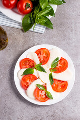 Close-up photo of caprese salad with ripe tomatoes, basil, buffalo mozzarella cheese. Italian and Mediterranean food concept. Fresh and healthy organic meal. Starter and antipasti. 