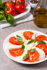 Close-up photo of caprese salad with ripe tomatoes, basil, buffalo mozzarella cheese. Italian and Mediterranean food concept. Fresh and healthy organic meal. Starter and antipasti. 