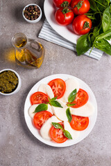 Close-up photo of caprese salad with ripe tomatoes, basil, buffalo mozzarella cheese. Italian and Mediterranean food concept. Fresh and healthy organic meal. Starter and antipasti. 