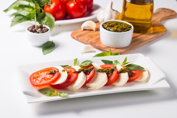 Close-up photo of caprese salad with ripe tomatoes, basil, buffalo mozzarella cheese. Italian and Mediterranean food concept. Fresh and healthy organic meal. Starter and antipasti. 
