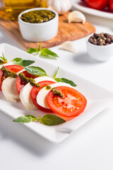 Close-up photo of caprese salad with ripe tomatoes, basil, buffalo mozzarella cheese. Italian and Mediterranean food concept. Fresh and healthy organic meal. Starter and antipasti. 