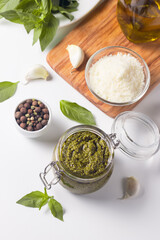 Basil pesto sauce in a jar. Ingredients for cooking, cheese, parmesan, garlic, olive oil. 