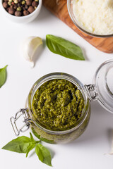 Basil pesto sauce in a jar. Ingredients for cooking, cheese, parmesan, garlic, olive oil. 