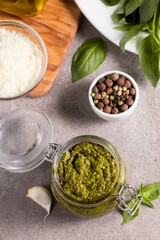 Basil pesto sauce in a jar. Ingredients for cooking, cheese, parmesan, garlic, olive oil. 