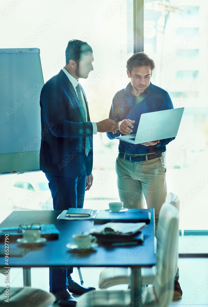 Poster project planning in the boardroom. shot of a two businessman working together on a laptop while stan