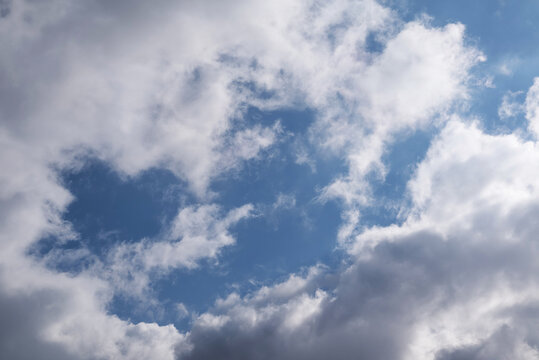 A blurry image of white-gray clouds against a blue sky.sky background.