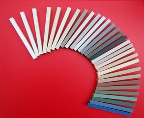 Grout plastic sample sticks in different colors on red background. Abstract layout.