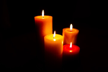 Burning red candles on black background