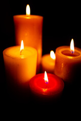 Burning red candles on black background