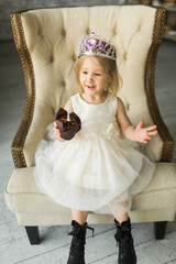 young princess celebrates her birthday. blows out the candle on the cake
