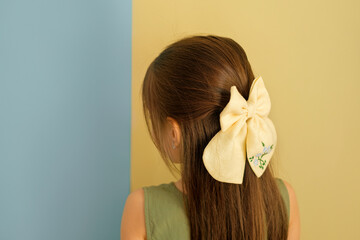 A beautiful big bow is an accessory for the hair on the girl's head. Long strong silky well-groomed...