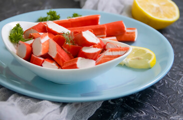 crab sticks in a plate on a dark background
