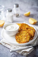 Potato hash browns with sour cream sauce in a plate