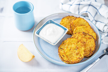 Potato hash browns with sour cream sauce in a plate