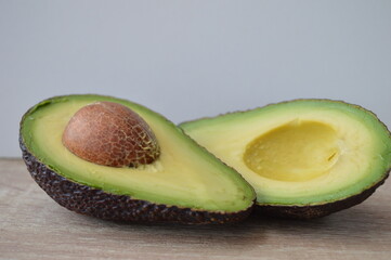 Sliced avocado on a wooden kitchen work table. Exotic fruits full of healthy nutrients