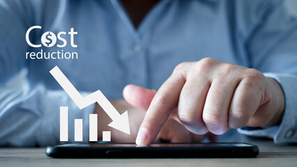 Cost reduction Concept. Businessman with his hand lowers the arrow of the graph. Cost text with a...