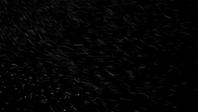 Blizzard snow particles blowing ferociously on a dark, foggy background.