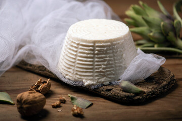 Fresh ricotta cheese on wooden background