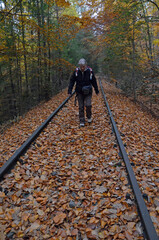 Fototapeta premium eine frau geht auf einer stillgelegten eisenbahnstrecke