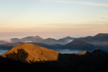 Mist and fog between valley and layers of mountains and hills at sunset, in Umbria Italy