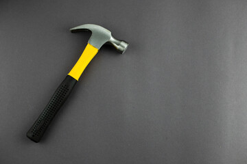 hammer tool in hands on a dark background