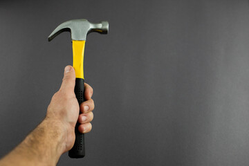 hammer tool in hands on a dark background