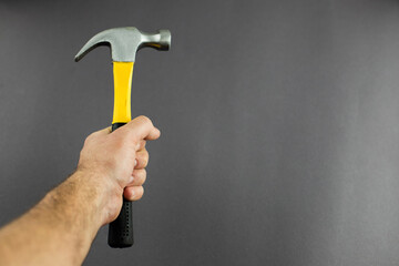 hammer tool in hands on a dark background
