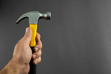 hammer tool in hands on a dark background