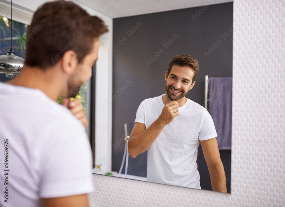 Poster i do look good with a beard though. cropped shot of a handsome man looking at himself in the mirror 