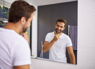 I do look good with a beard though. Cropped shot of a handsome man looking at himself in the mirror whilst touching his beard at home. - Powered by Adobe